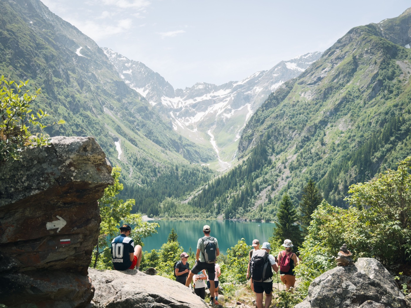 Wandernde mit Blick auf einen Bergsee